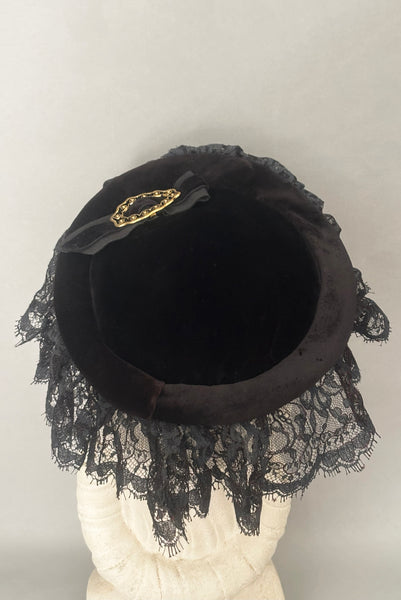 Detail back view of 1950s vintage black velvet and lace one size pancake cocktail hat with ribbon and gold tone metal buckle, by Lemington for Frederick & Nelson.
