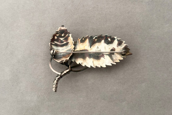 Horizontal back view of 1950s vintage Gertrud Engel 925 sterling silver Danish modernist leaf and berry botanical brooch for Anton Michelsen, made in Denmark.