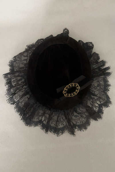 Vertical top view of 1950s vintage black velvet and lace one size pancake cocktail hat with ribbon and gold tone metal buckle, by Lemington for Frederick & Nelson.