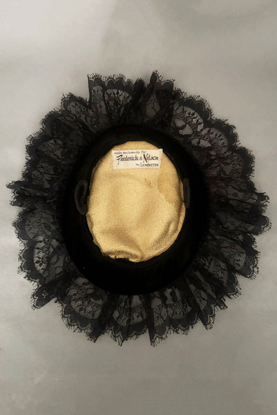 Vertical interior view of 1950s vintage black velvet and lace one size pancake cocktail hat with ribbon and gold tone metal buckle, by Lemington for Frederick & Nelson.