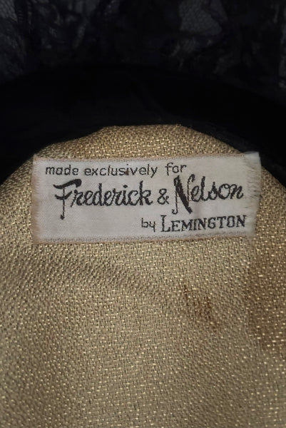 Detail view of 1950s vintage black velvet and lace one size pancake cocktail hat with ribbon and gold tone metal buckle, by Lemington for Frederick & Nelson. Showing a close up of the Frederick & Nelson label and darkened areas on the gold lining.