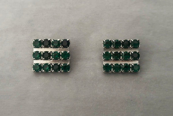 Horizontal front view of 1960s vintage large rectangular silver tone and round emerald green rhinestone clip-on earrings.
