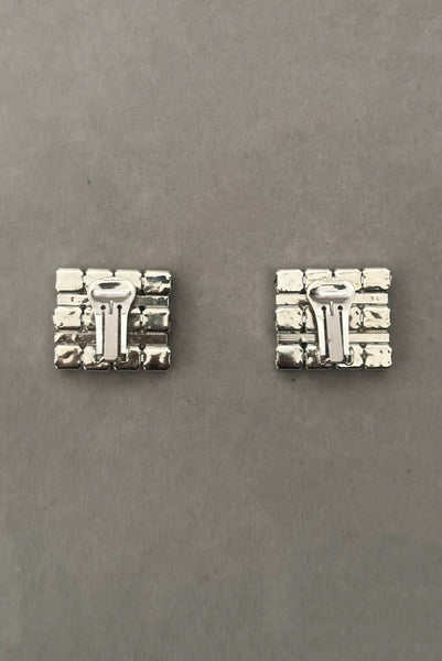 Vertical back view of 1960s vintage large rectangular silver tone and round emerald green rhinestone clip-on earrings.