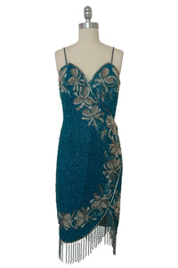 Front view of 1980s vintage sweetheart neckline turquoise blue asymmetrical fringed beaded cocktail dress, size small to medium.