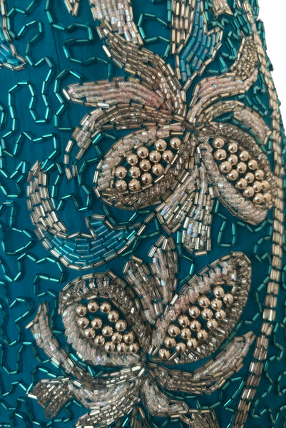 Detail view of 1980s vintage sweetheart neckline turquoise blue asymmetrical fringed beaded cocktail dress, size small to medium. Showing a small area of pink beading.