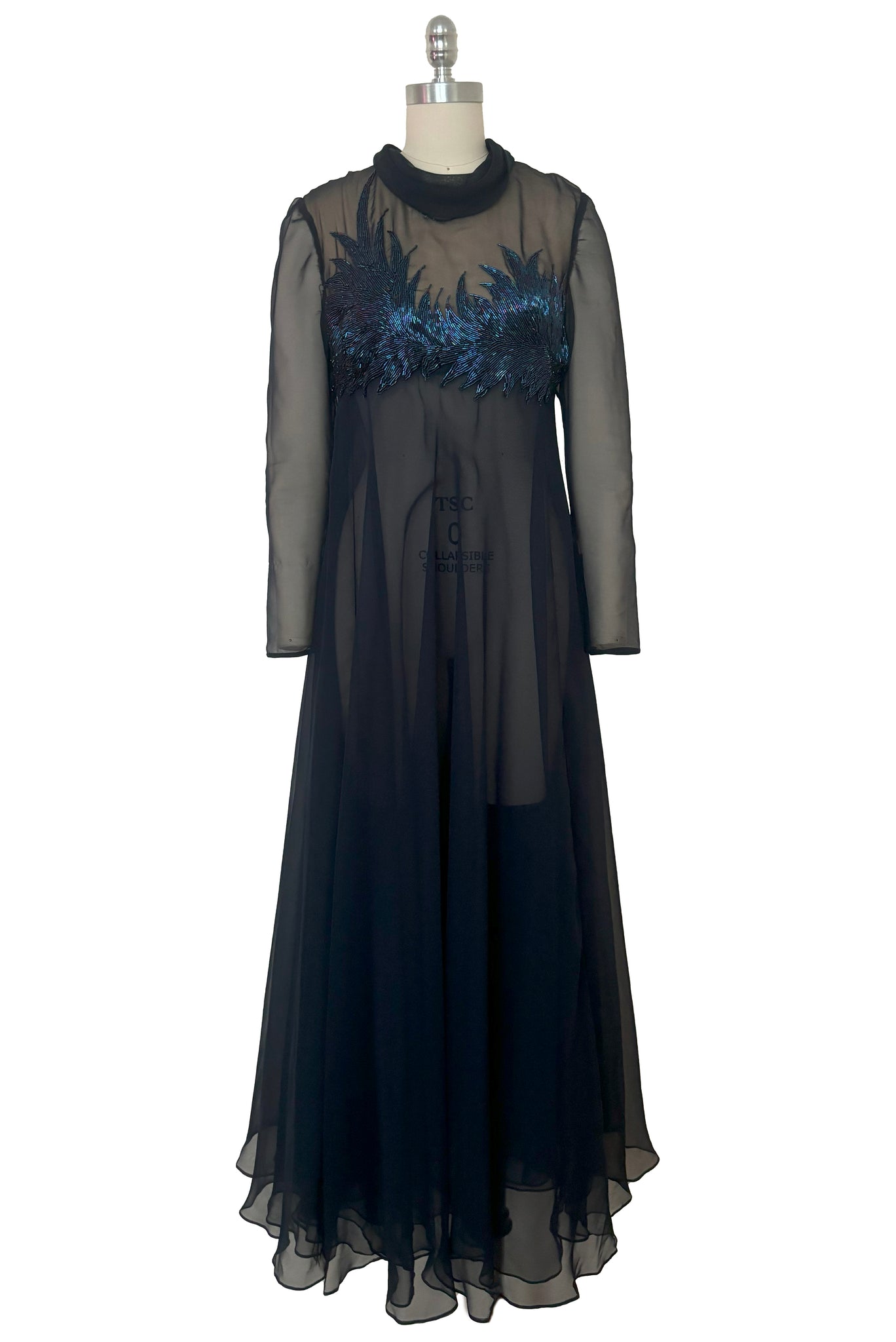 Front view of 1960s vintage navy blue chiffon long sleeve, high neck sheer evening gown with iridescent blue beaded bust, small to medium.