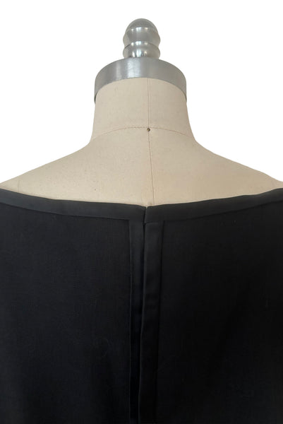 Detail view of 1950s vintage black imported linen satin and bow trimmed sheath dress, size small to medium. Showing back of the satin trimmed neckline.