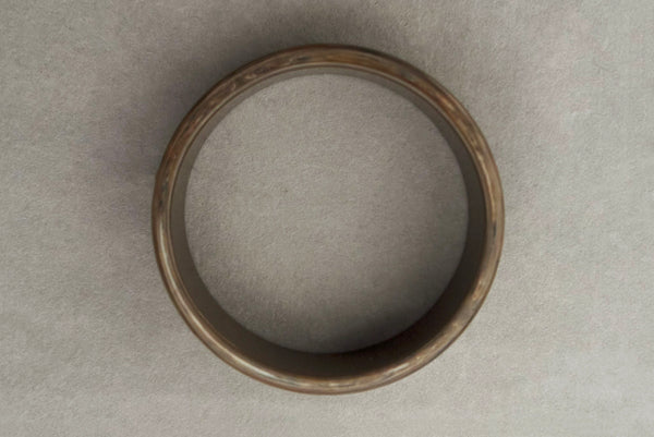 Horizontal top view of 1950s vintage gray and brown marbled Lucite plastic sliced bangle bracelet.