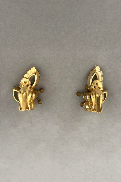 Vertical back view of 1950s vintage gray and iridescent rhinestone gold tone clip-on earrings.