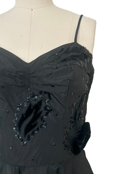 Bodice detail view of 1950s vintage black taffeta sequin applique cocktail dress embellished with black velvet roses, size extra extra small to extra small. Showing the black velvet leaf appliques embellished with sequins and 3 dimensional roses.