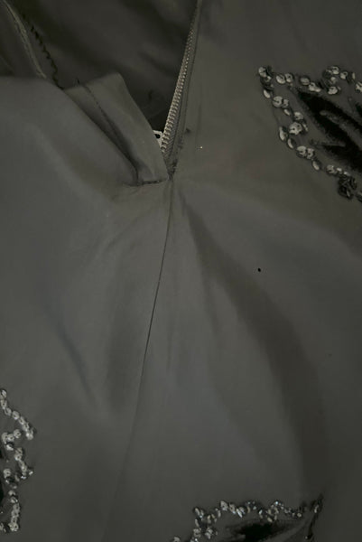 Skirt detail view of 1950s vintage black taffeta sequin applique cocktail dress embellished with black velvet roses, size extra extra small to extra small. Showing some scattered tiny holes.