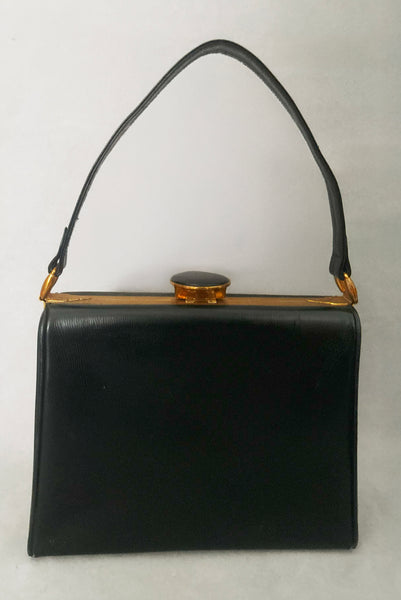 Vertical back view of 1930s vintage Art Deco black leather gold frame handbag by Evans with coin purse, mirror, comb, and lipstick holder.