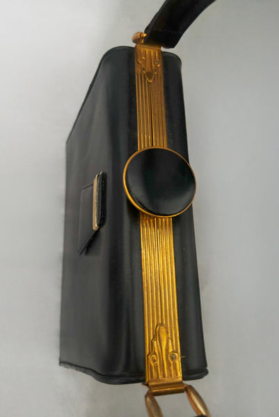 Detail view of 1930s vintage Art Deco black leather gold frame handbag by Evans with coin purse, mirror, comb, and lipstick holder. Showing the Art Deco details on the frame, and the knob shaped clasp.