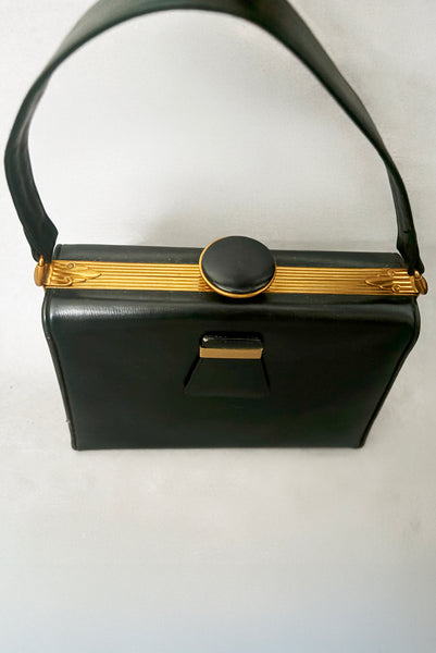 Detail view of 1930s vintage Art Deco black leather gold frame handbag by Evans with coin purse, mirror, comb, and lipstick holder. Showing the Art Deco details on the frame, and the knob shaped clasp.