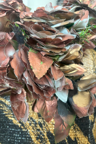 Detail view of 1960s vintage metallic black, gold, and white lurex fancy dress costume with copper painted silk flower collar, size medium to large. Showing a close up of the copper painted flowers.