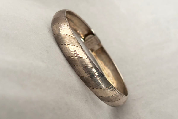 Horizontal perspective view of 1970s vintage stripe engraved Italian 925 sterling silver bangle bracelet made in Salerno, Italy.