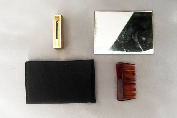 Detail view of 1930s vintage Art Deco black leather gold frame handbag by Evans with coin purse, mirror, comb, and lipstick holder. Showing the mirror with black faille case, pocket comb, and lipstick holder.