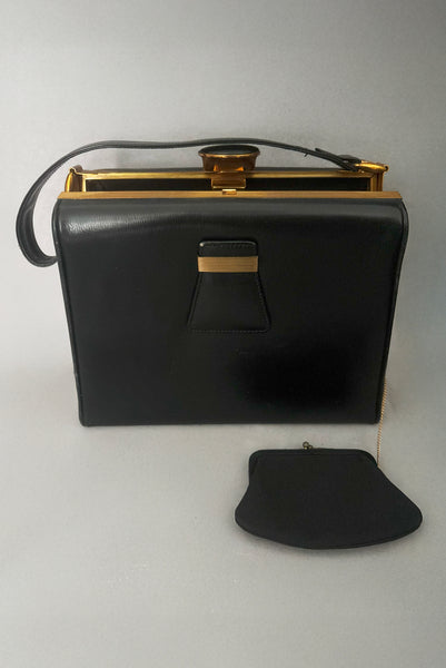 Detail view of 1930s vintage Art Deco black leather gold frame handbag by Evans with coin purse, mirror, comb, and lipstick holder. Showing the black faille coin purse attached to the bag by a delicate gold chain.