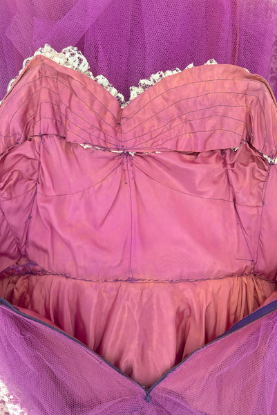Interior detail view of as is 1950s vintage purple tulle and cream lace strapless ruffled evening dress, size extra small to small. Showing extensive discoloration to the acetate.