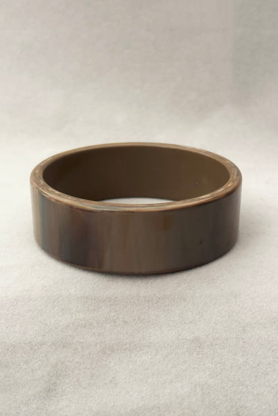 Vertical front view of 1950s vintage gray and brown marbled Lucite plastic sliced bangle bracelet.