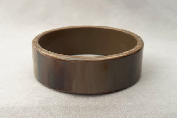 Horizontal front view of 1950s vintage gray and brown marbled Lucite plastic sliced bangle bracelet.