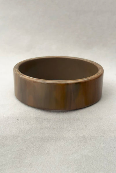 Vertical front view of 1950s vintage gray and brown marbled Lucite plastic sliced bangle bracelet.