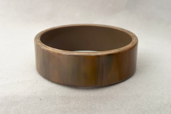 Horizontal front view of 1950s vintage gray and brown marbled Lucite plastic sliced bangle bracelet.