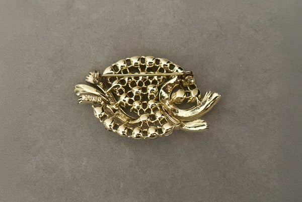 Horizontal back view of 1950s vintage oval iridescent fuchsia pink rhinestone and champagne metal brooch, by Lisner.