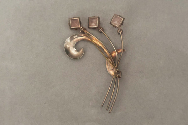 Horizontal back view of 1950s vintage 925 sterling silver, square princess cut pink rhinestone, and round clear rhinestone modernist floral botanical brooch.