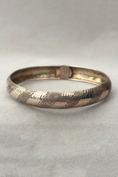 Vertical front view of 1970s vintage stripe engraved Italian 925 sterling silver bangle bracelet made in Salerno, Italy.