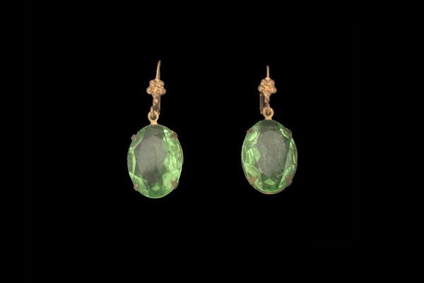 Horizontal front view of 2010s vintage faceted glass oval peridot green rhinestone and brass lever back drop earrings made from vintage components.