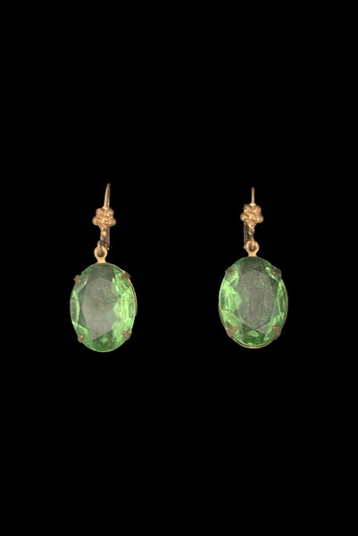Vertical front view of 2010s vintage faceted glass oval peridot green rhinestone and brass lever back drop earrings made from vintage components.