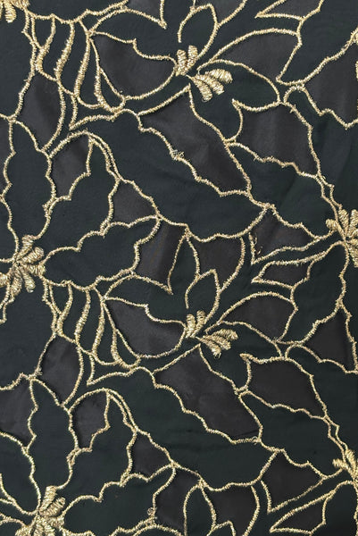 Detail view of 1980s vintage black & gold floral embroidered one shoulder ruffled silk evening dress, size extra small to small. Showing a close-up of the gold floral embroidered black silk chiffon with black silk taffeta behind it.