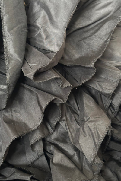 Detail view of 1980s vintage black & gold floral embroidered one shoulder ruffled silk evening dress, size extra small to small. Showing a close-up of the black silk taffeta ruffles.