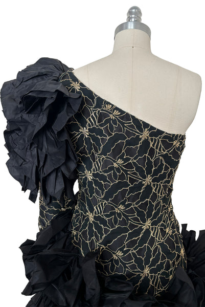 Bodice back view of 1980s vintage black & gold floral embroidered one shoulder ruffled silk evening dress, size extra small to small. Showing the gold floral embroidered ruffled one shoulder bodice with dropped waist.