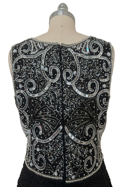 Bodice back view of 1980s vintage Art Deco faux pearl, silver and black glass beaded black silk chiffon evening dress, size small to medium. With a scoop neckline, sleeveless bodice, and floor length pencil skirt.