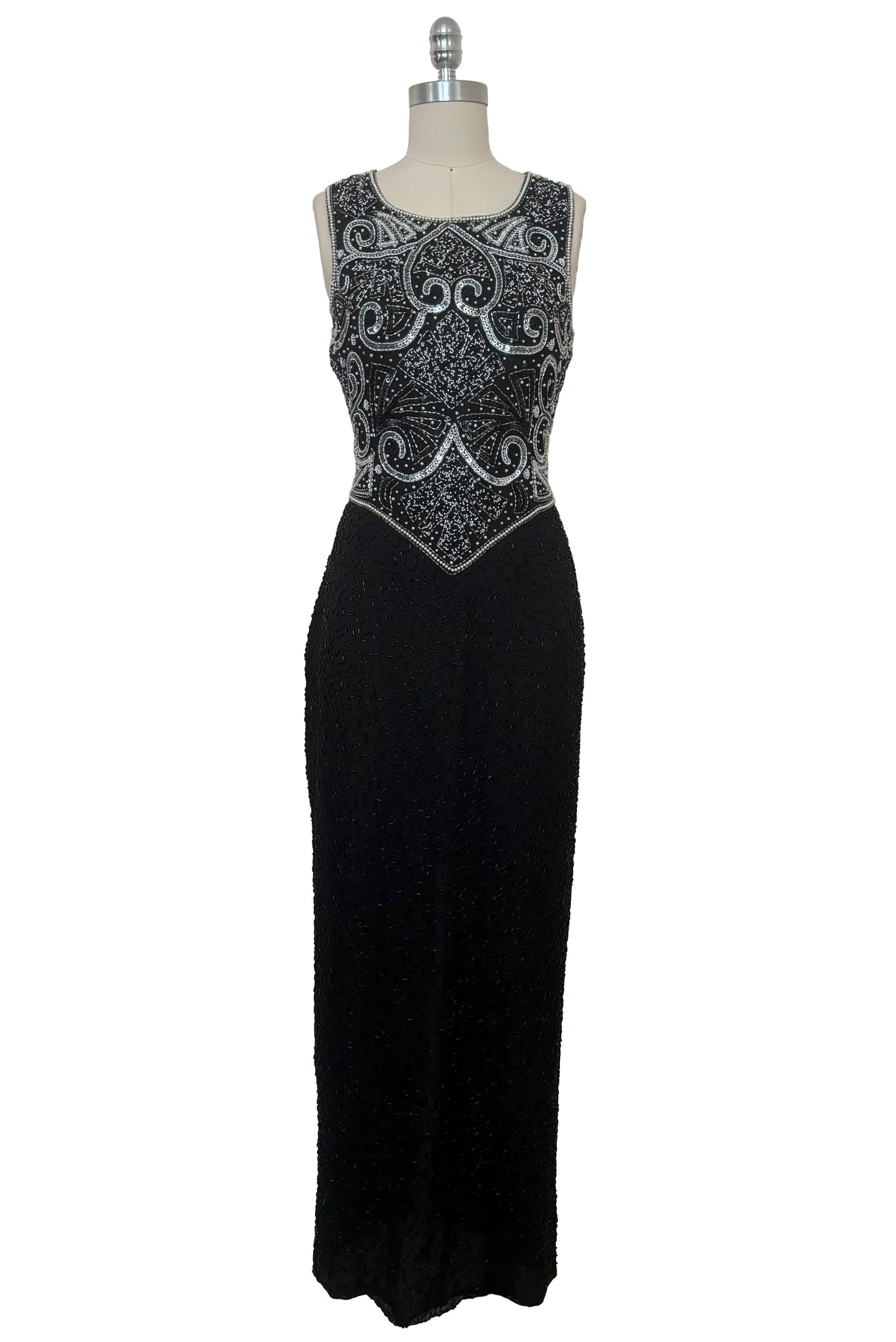 Front view of 1980s vintage Art Deco faux pearl, silver and black glass beaded black silk chiffon evening dress, size small to medium. With a scoop neckline, sleeveless bodice, and floor length pencil skirt.
