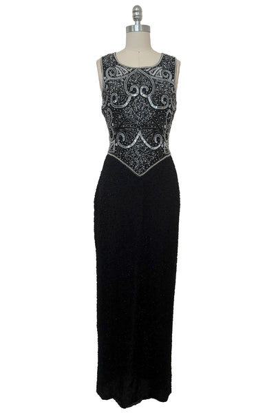 Front view of 1980s vintage Art Deco faux pearl, silver and black glass beaded black silk chiffon evening dress, size small to medium. With a scoop neckline, sleeveless bodice, and floor length pencil skirt.