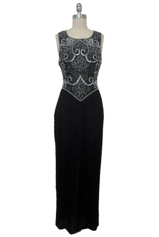 Front view of 1980s vintage Art Deco faux pearl, silver and black glass beaded black silk chiffon evening dress, size small to medium. With a scoop neckline, sleeveless bodice, and floor length pencil skirt.