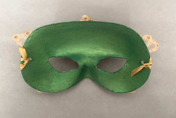 Horizontal back view of 1990s gold Lurex lace, gold Swarovski crystal, and metallic green painted half mask with gold satin ribbon ties. Showing the inside of the mask.