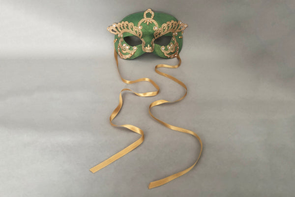 Horizontal front view of 1990s gold Lurex lace, gold Swarovski crystal, and metallic green painted half mask with gold satin ribbon ties. Showing the gold satin ribbon ties.