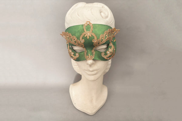 Horizontal front view of 1990s gold Lurex lace, gold Swarovski crystal, and metallic green painted half mask with gold satin ribbon ties. Showing the mask on a mannequin head.