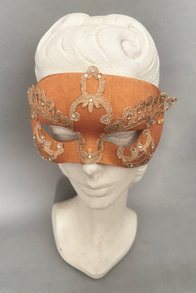 Vertical front view of 1990s gold Lurex lace, gold Swarovski crystal, and metallic pink rose gold painted half mask with gold satin ribbon ties. Showing the mask on a mannequin head.