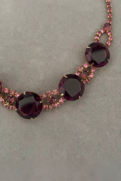 Detail view of 1950s vintage pink and large Purple rhinestone adjustable gold tone necklace. Showing a close-up of the front of the necklace.