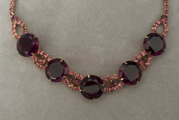Detail view of 1950s vintage pink and large Purple rhinestone adjustable gold tone necklace. Showing a close-up of the front of the necklace.