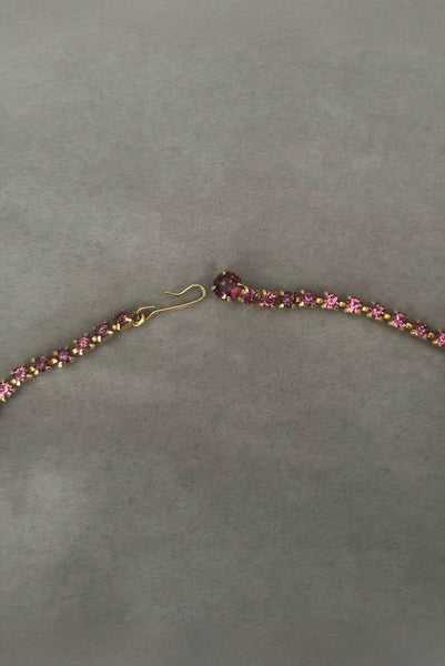 Detail view of 1950s vintage pink and large Purple rhinestone adjustable gold tone necklace. Showing a close-up of the hook closure.