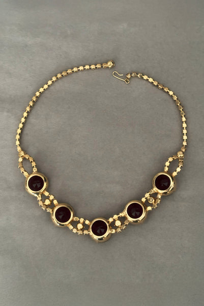 Vertical flat lay back view of 1950s vintage pink and large Purple rhinestone adjustable gold tone necklace.