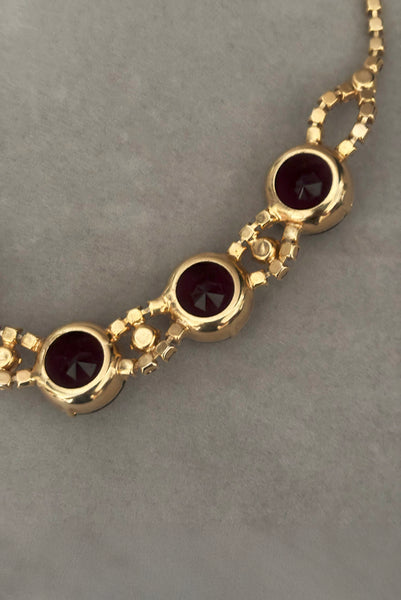 Detail view of 1950s vintage pink and large Purple rhinestone adjustable gold tone necklace. Showing a close-up of the gold tone setting.