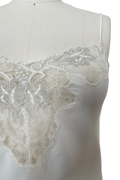 Detail view of 1970s vintage white polyester challis and floral lace faux pearl embellished lingerie camisole top by Christian Dior, size small to medium.  Showing the floral lace neckline.