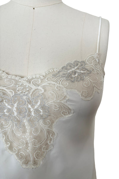 Detail view of 1970s vintage white polyester challis and floral lace faux pearl embellished lingerie camisole top by Christian Dior, size small to medium.  Showing the floral lace neckline and faux pearl details.